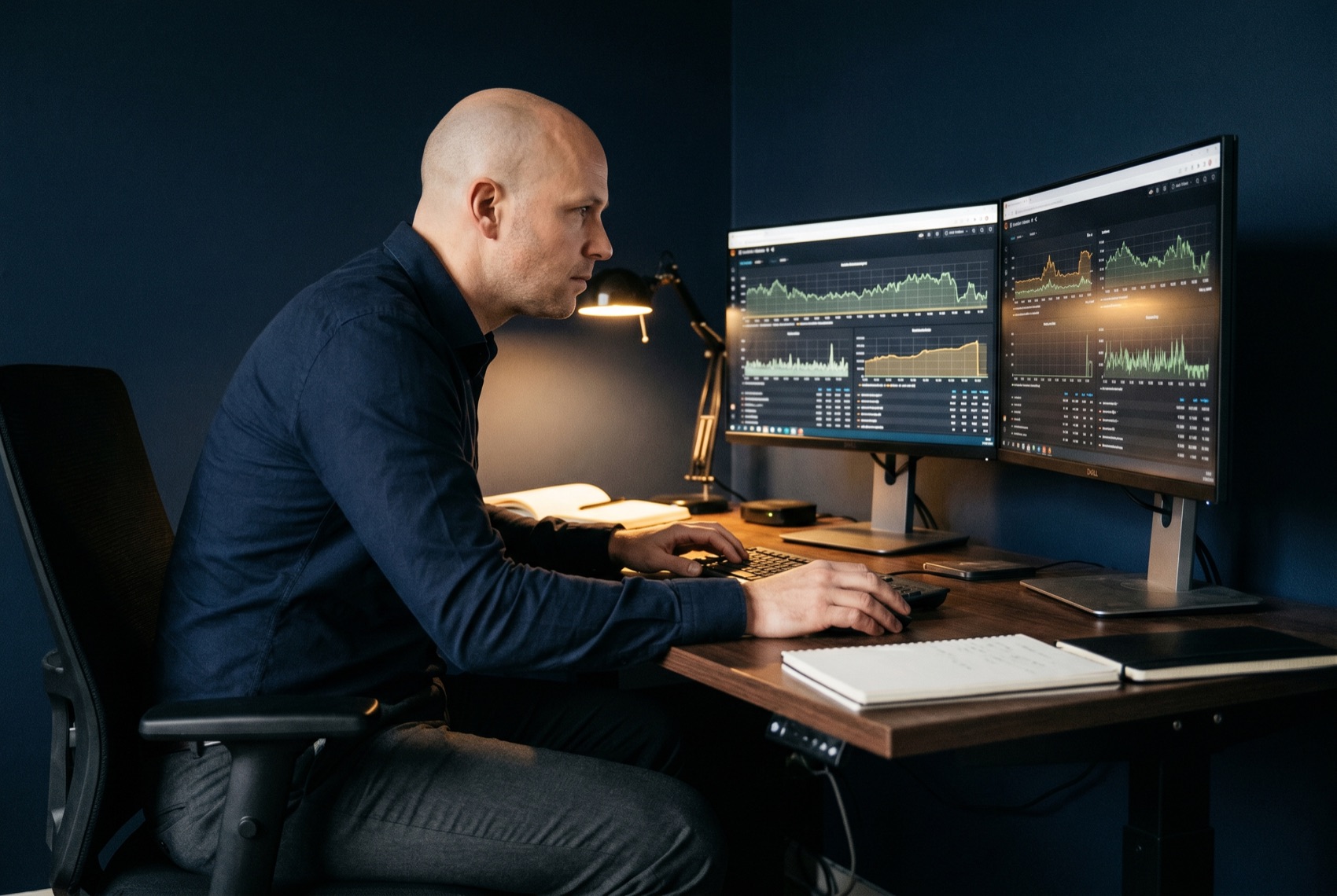A performance QA engineer reviewing k6 load shapes and latency budgets on a Grafana dashboard